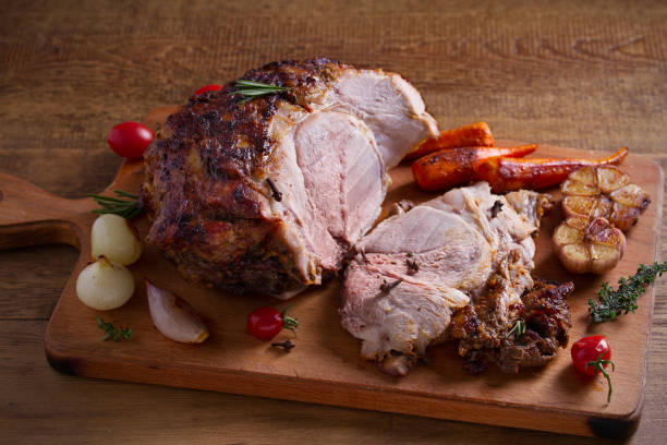 istock Baked ham with vegetables, rosemary and thyme on chopping board 1064075618