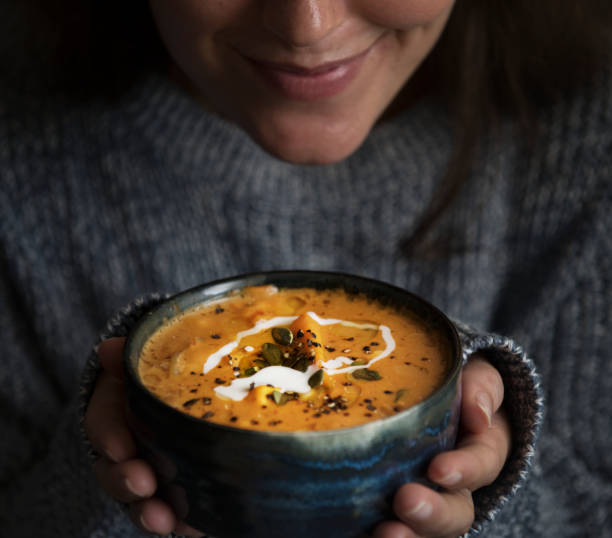 mujer que sostiene un tazón de fuente de la idea de receta de sopa comida fotografía - tasting women eating expressing positivity fotografías e imágenes de stock