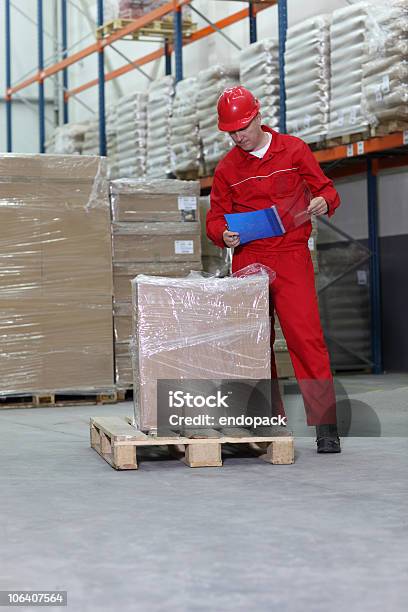 Photo libre de droit de Travailleur Vérifier Linventaire Stocks Chez Un Storeroom banque d'images et plus d'images libres de droit de Adulte