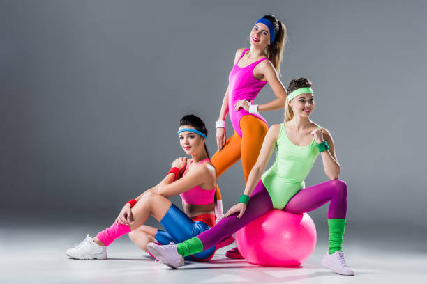 beautiful athletic women in 80s style sportswear posing together on grey beautiful athletic women in 80s style sportswear posing together on grey 80s aerobics stock pictures, royalty-free photos & images