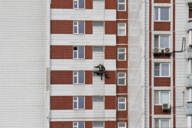 construction worker reconstructing the facade of an apartment building in moscow - reconstructing imagens e fotografias de stock