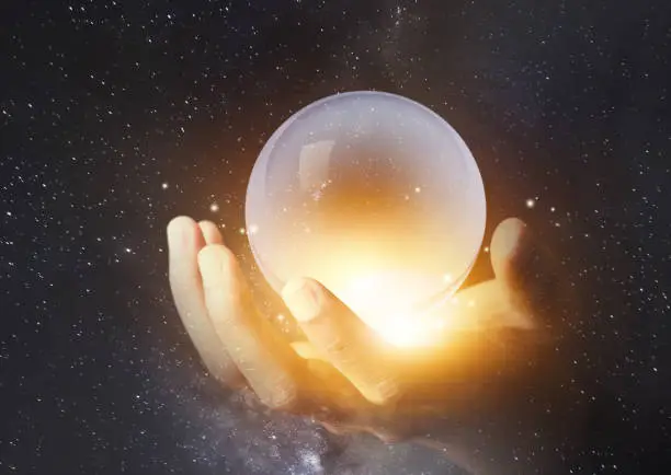 Photo of businessman hand holding crystal clear ball with galaxy universe space background