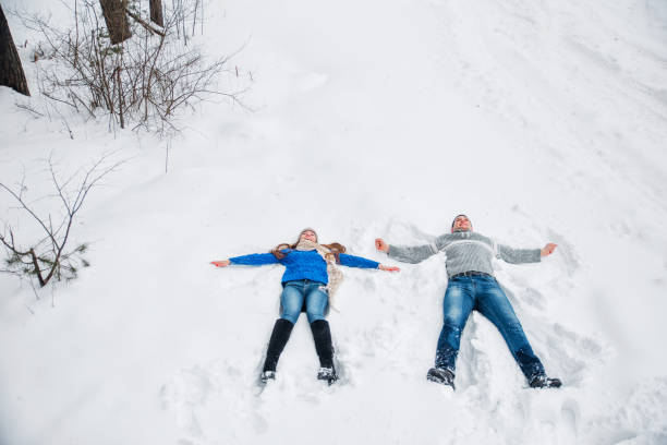 istock Couple Lying On Snow Making Snow Angel. Winter vacation 1064090766