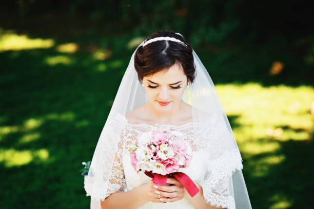 istock Beautiful brunette bride with bouquet outdoor. 1064090828