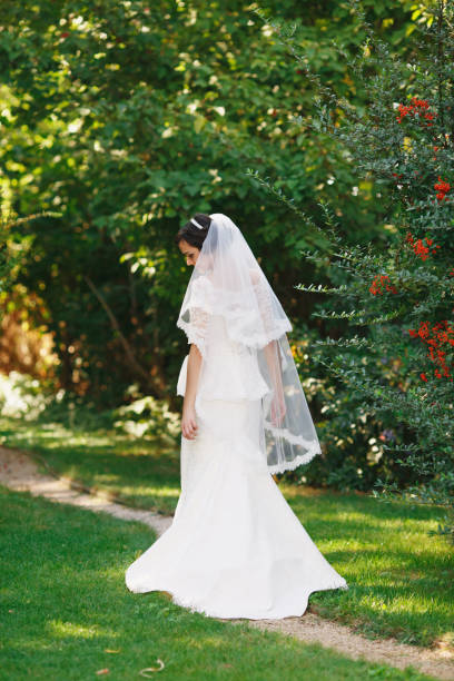 istock Beautiful brunette bride with bouquet outdoor. 1064091384