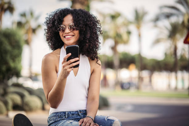 istock Cute skater woman using phone 1064103456