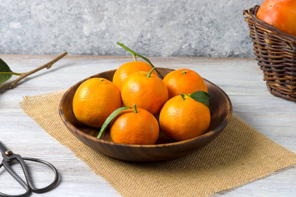 istock Clementines in a wooden basket, on a rustic wooden background 1064104096