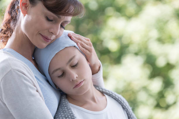 istock Caregiver hugging sick and weak kid with cancer during chemotherapy 1064106656