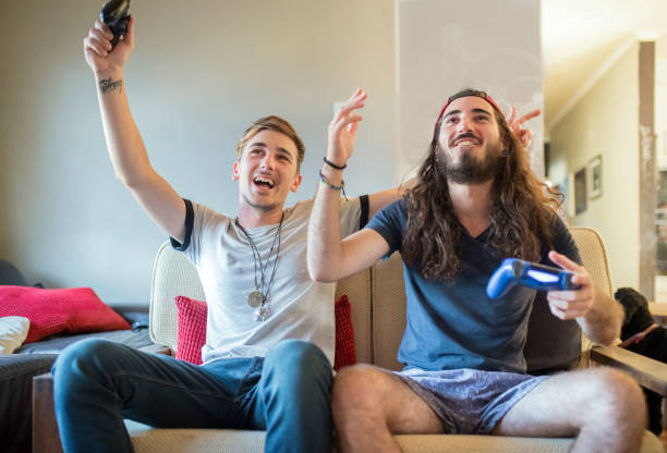 istock Happy men holding controllers with arms raised 1064108626