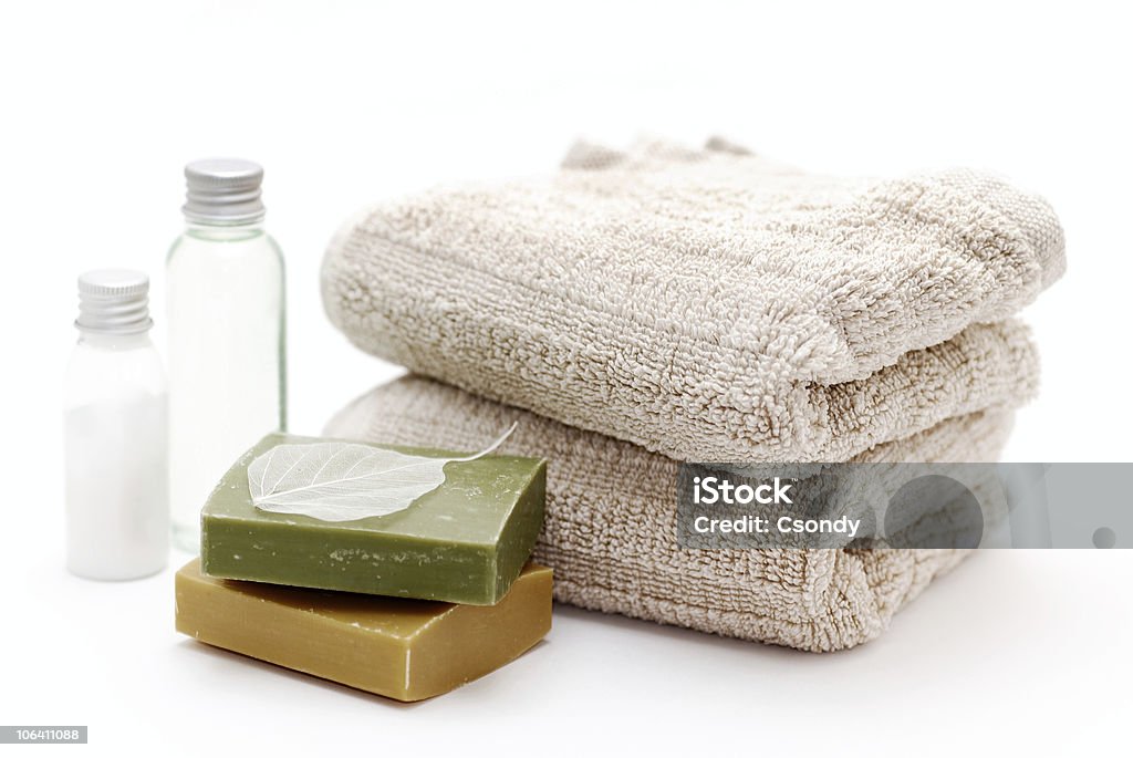 Bathroom Bath accessories - towels, soaps (green and orange), body lotion and shampoo on white background. Shampoo Stock Photo