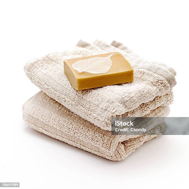 An Unwrapped Bar Of Soap Atop Two Folded Tan Bath Towels Stock Photo - Download Image Now