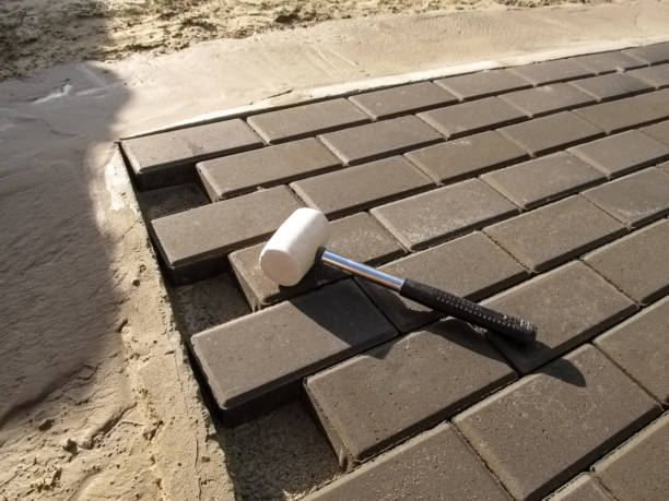 nova pavimentação lajes 'tijolo' sexo, martelo de calçada de concreta e uma borracha branca - rubber mallet - fotografias e filmes do acervo