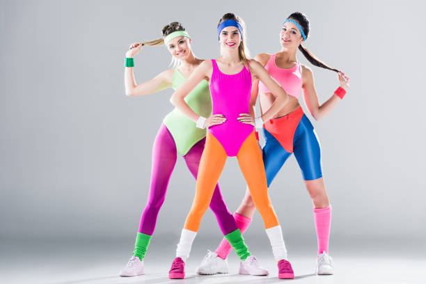three happy sporty girls standing together and smiling at camera on grey three happy sporty girls standing together and smiling at camera on grey 80s aerobics stock pictures, royalty-free photos & images
