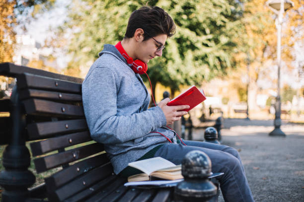 istock Student reading a book in the park 1064119802