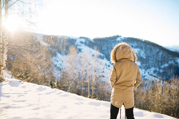 Women standing on cliff and enjoying view of winter landscape
