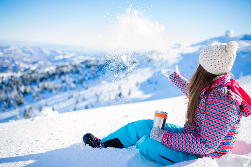 Teenage girl enjoys at snowy mountain