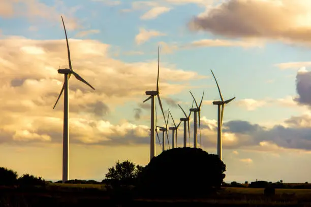 Photo of Wind turbines in a wind power plant at sunset, on a cloudy day in Spain