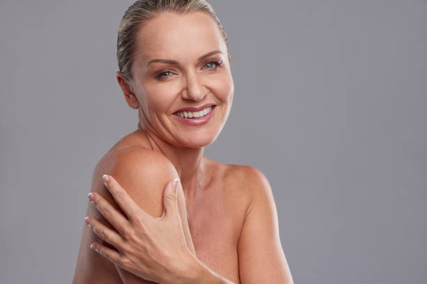 Looking youthful and radiant Studio shot of an attractive mature woman posing against a grey background strapless stock pictures, royalty-free photos & images