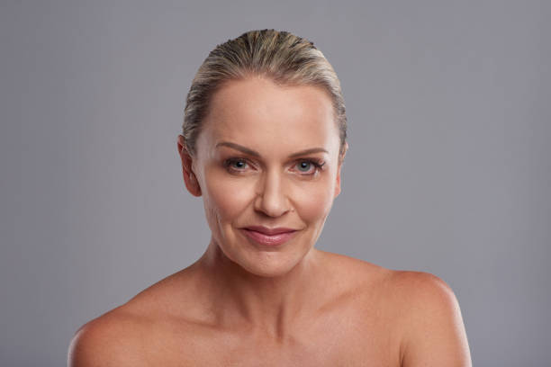 Studio portrait of an attractive mature woman posing against a grey background