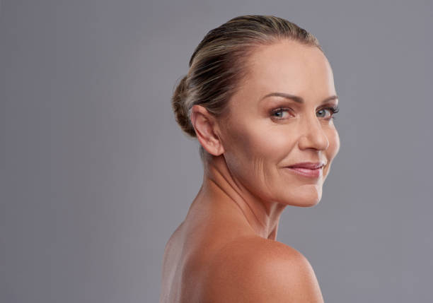 Studio portrait of an attractive mature woman posing against a grey background