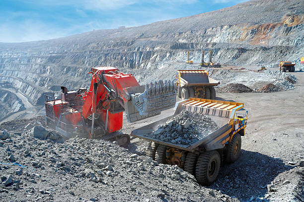 Iron ore loaded into a machine Loading of iron ore on very big dump-body truck open pit mine photos stock pictures, royalty-free photos & images