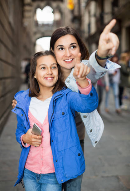 istock Mother and daughter looking at guide in phone 1064136230