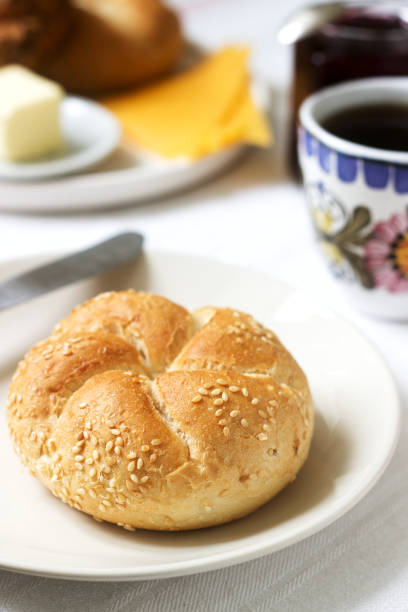 Breakfast with Kaiser rolls, currant jam, butter and cheese and tea. Selective focus.