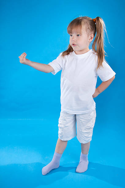 Pequeña niña graves se posando aislado sobre azul - foto de stock