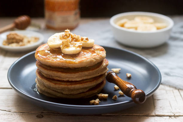 istock Pancakes with banana, nuts and honey, served with tea. Rustic style. 1064139858