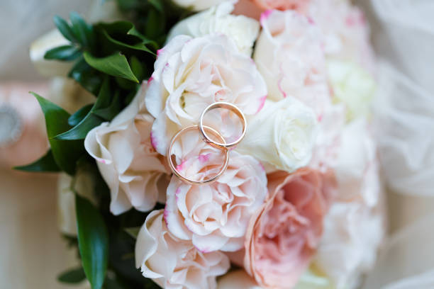 istock wedding golden rings with pastel pink rose 1064145252