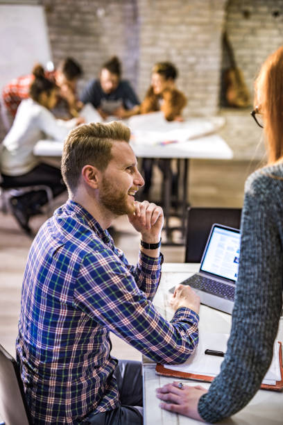 istock Happy creative man talking to his colleague while working at casual office. 1064147822