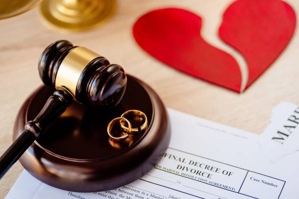 istock Two broken golden wedding rings on judge gavel. 1064149166