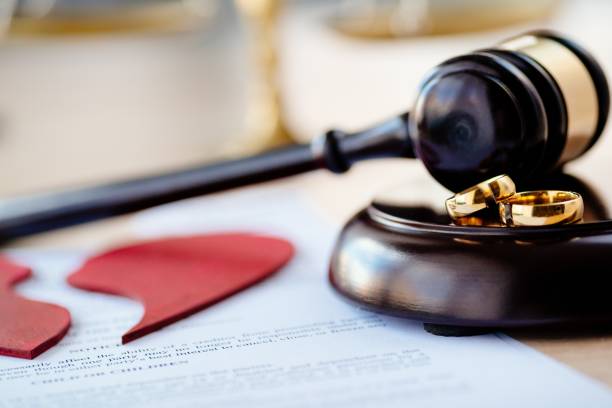 istock Two broken wedding rings on judge gavel 1064149380