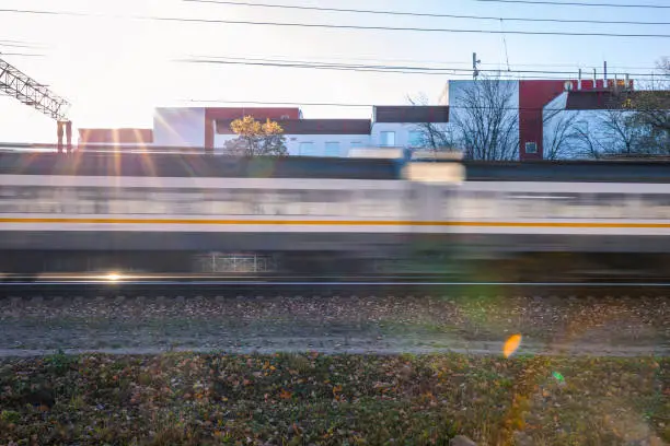 The train moves at speeds by rail. Focus blurred against the sun.