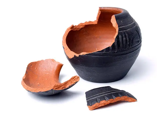 Broken antique clay pot on a white background