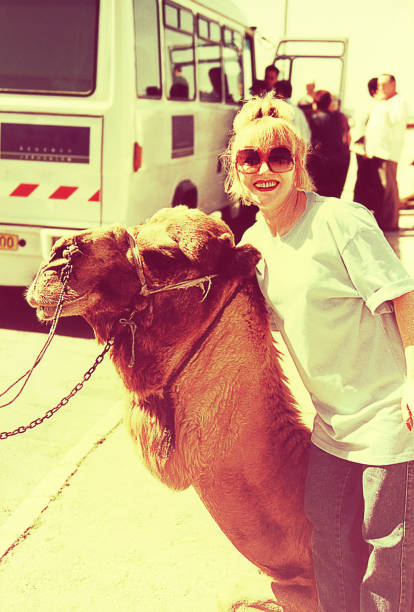 Vintage tourist woman with a camel Vintage image of a woman with a camel on a visit to Jerusalem. jerusalem photos stock pictures, royalty-free photos & images