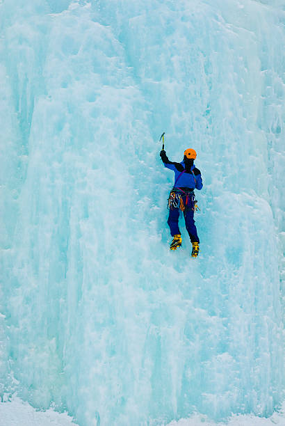 man iceclimbing た凍った滝 - アイスクライ�ミング ストックフォトと画像