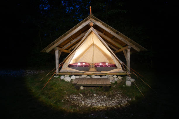 night shot of illuminated tents in adrenaline check eco camp, slovenia. - home interior cabin shack european alps imagens e fotografias de stock