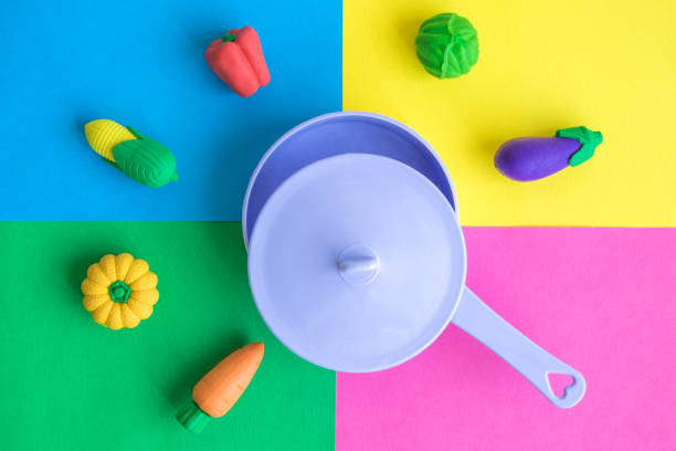 istock Flat lay of plastic pan with various rubber toy vegetables on colorful background minimal creative concept. 1064160830