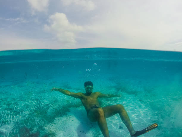 istock Underwater split screen view of man diving apnea. 1064161294