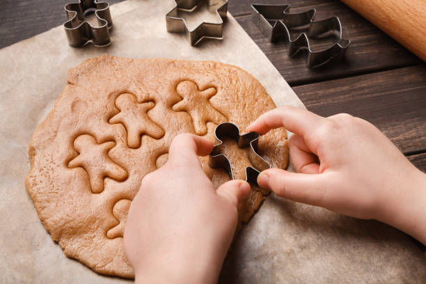 istock Child hands making festive Christmas gingerbread cookies 1064162248
