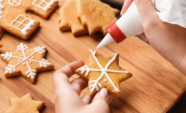 istock Christmas bakery. Woman decorating homemade gingerbread cookie 1064162280