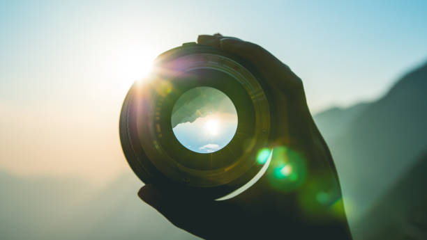 istock Hand holding camera lens at sunset 1064163644