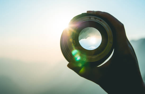 istock Hand holding camera lens at sunset 1064163650