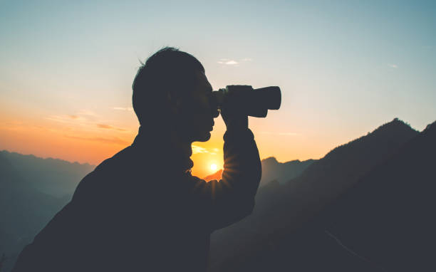 istock Man looks through binoculars in mountain 1064164370