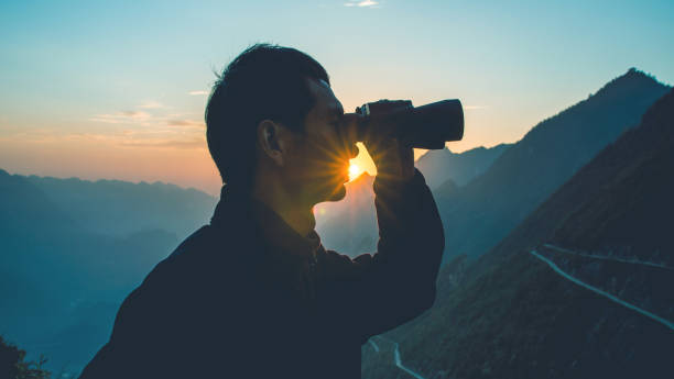 istock Man looks through binoculars in mountain 1064164498