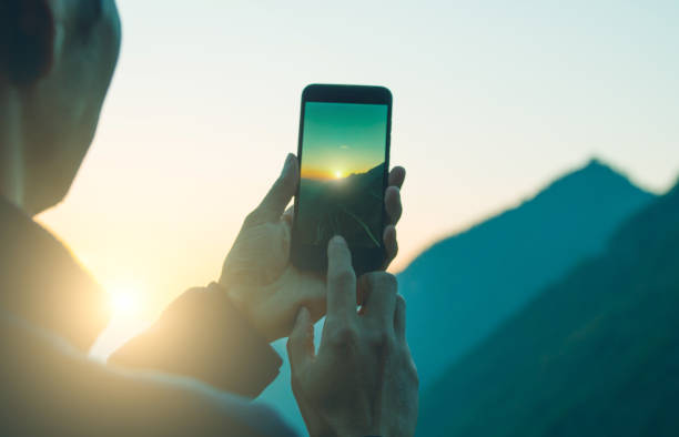istock Man photographing mountain with mobile phone 1064164602