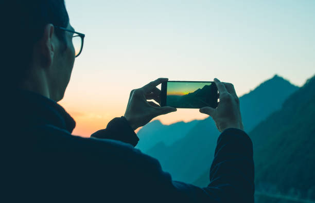 istock Man photographing mountain with mobile phone 1064164728