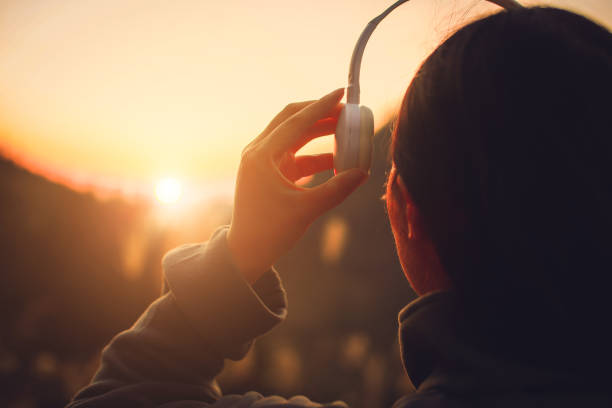 istock Young woman with headset at sunset 1064169832