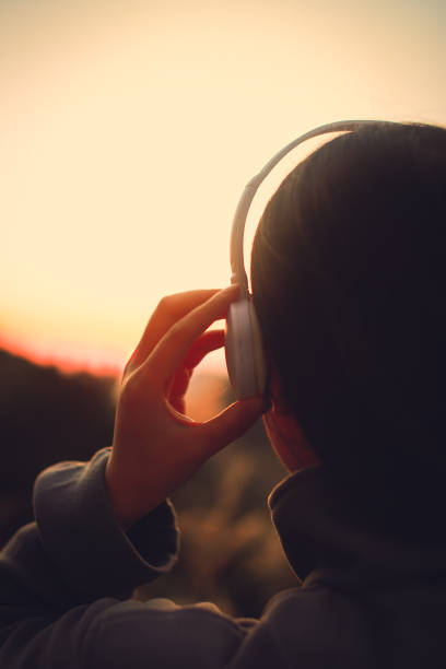 headphones in the hands of a woman. listening music.